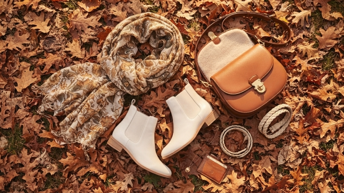 Easy Ways to Transition Your Wardrobe, Flat lay of fall transitional accessories including ankle boots, scarf, and leather bag