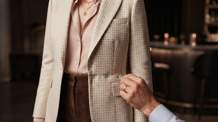 Close-up of tailoring process showing waistline adjustment on a blazer.